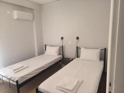 two beds in a small room with white walls at Casa Dili Stylish 2BR Apartment in Athens