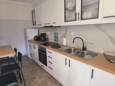 a kitchen with white cabinets and a sink at Casa Dili Stylish 2BR Apartment in Athens