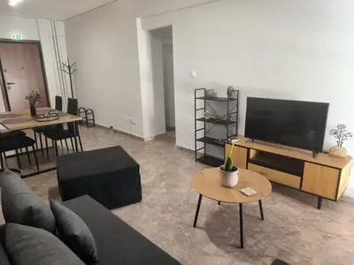 a living room with a couch and a flat screen tv at Casa Dili Stylish 2BR Apartment in Athens