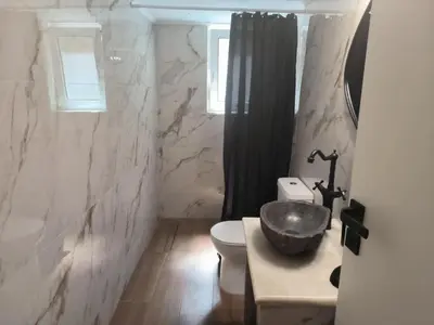 a bathroom with a sink and a toilet and a window at Casa Dili Stylish 2BR Apartment in Athens