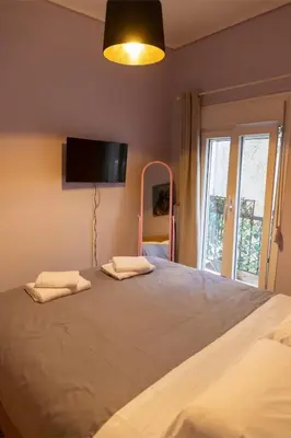 a bedroom with a large bed with a tv on the wall at Pop Art Escape - Zografou by ΜΡS in Athens