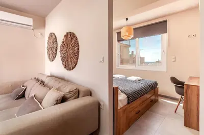 a bedroom with a couch and a bed and a window at Highly aesthetic apartment in Glyfada in Athens