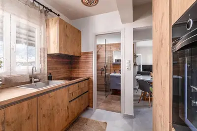 a kitchen with wooden cabinets and a sink at Highly aesthetic apartment in Glyfada in Athens