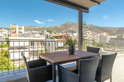 a table and chairs on a balcony with a view at Highly aesthetic apartment in Glyfada in Athens