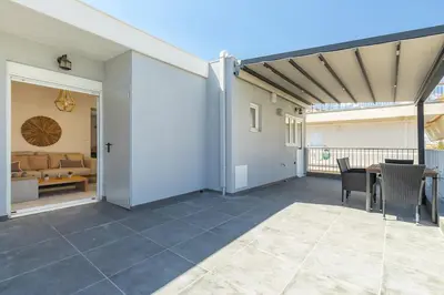an open patio with a couch and a table at Highly aesthetic apartment in Glyfada in Athens