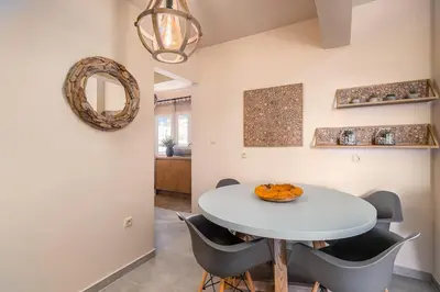 a dining room with a white table and chairs at Highly aesthetic apartment in Glyfada in Athens