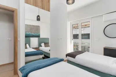 a bedroom with three beds and a window at Acropolis Oasis - 2BR, Koukaki in Athens