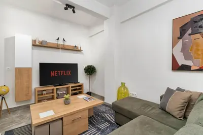 a living room with a couch and a tv at Acropolis Oasis - 2BR, Koukaki in Athens