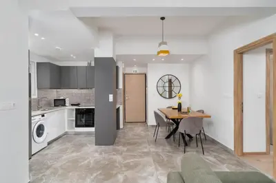 a kitchen and dining room with a table and chairs at Acropolis Oasis - 2BR, Koukaki in Athens