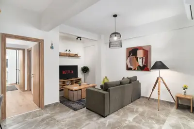 a living room with a couch and a table at Acropolis Oasis - 2BR, Koukaki in Athens