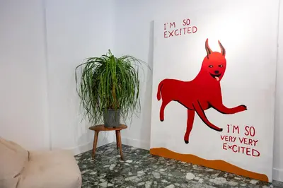 a wall with a red dog on it next to a plant at Navarino Athenian Nest in Athens