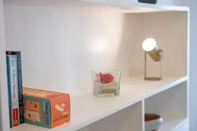 a shelf with books and a candle and a lamp at Navarino Athenian Nest in Athens