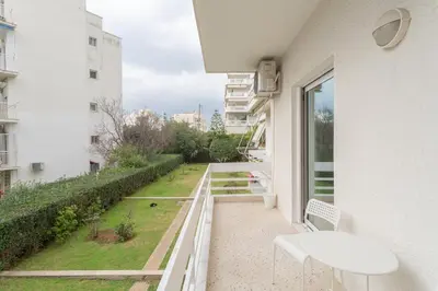 a balcony with a view of a garden at Beachside Apartment - Available per month in Athens