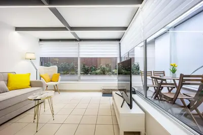 a living room with a couch and a table at Urban Patio Apartment in Athens