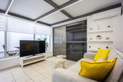 a living room with a couch and a tv at Urban Patio Apartment in Athens
