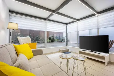 a living room with a couch and a flat screen tv at Urban Patio Apartment in Athens