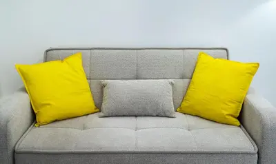 two yellow pillows sitting on a gray couch at Urban Patio Apartment in Athens
