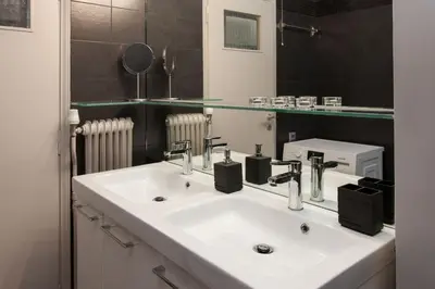 a bathroom with a white sink and a mirror at Modern Comfort 2 bdrm Apartment in Voula in Athens