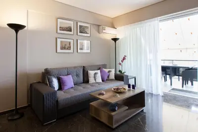 a living room with a couch and a table at Modern Comfort 2 bdrm Apartment in Voula in Athens