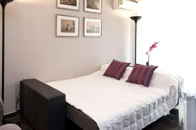 a small bedroom with a bed with purple pillows at Modern Comfort 2 bdrm Apartment in Voula in Athens