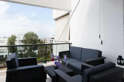 a balcony with black chairs and a table with flowers at Modern Comfort 2 bdrm Apartment in Voula in Athens