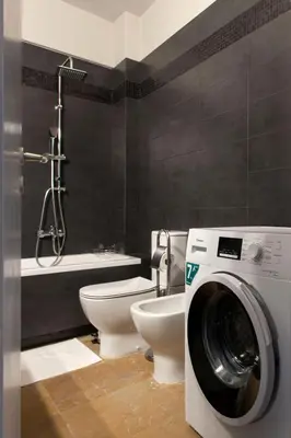 a bathroom with a toilet and a washing machine at Modern Comfort 2 bdrm Apartment in Voula in Athens