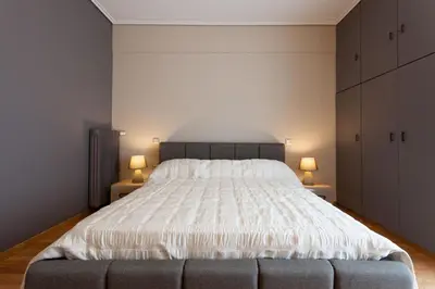 a bedroom with a large white bed with two lamps at Modern Comfort 2 bdrm Apartment in Voula in Athens