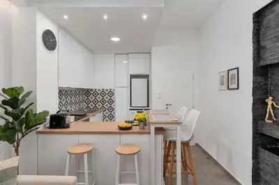 a kitchen with white walls and a counter with stools at Urban Nest - Studio, Neos Kosmos in Athens