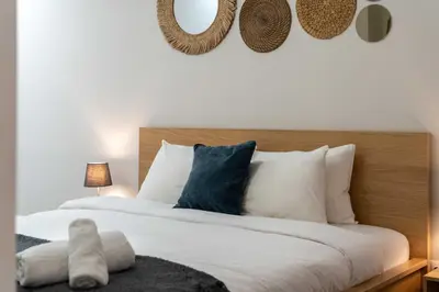 a bedroom with a large bed with white and blue pillows at Urban Nest - Studio, Neos Kosmos in Athens