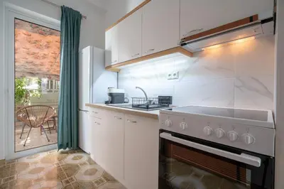a white kitchen with a sink and a stove at Petrαlonα 1-Bdr cοmfort, neαr Metro by Traser in Athens
