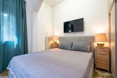 a bedroom with a bed and a tv on the wall at Petrαlonα 1-Bdr cοmfort, neαr Metro by Traser in Athens