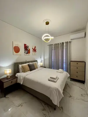 a bedroom with a large bed and two lamps at Cozy Apartment in Central Athens in Athens
