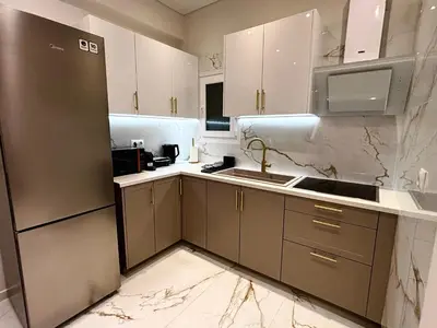 a kitchen with white cabinets and a stainless steel refrigerator at Cozy Apartment in Central Athens in Athens