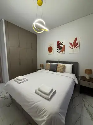 a bedroom with a large white bed with towels on it at Cozy Apartment in Central Athens in Athens