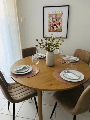 a wooden table with plates and wine glasses on it at MediTerra Stay Voula Beach in Athens