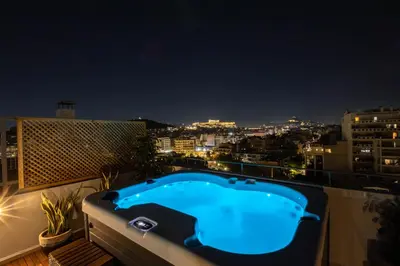 a hot tub on a balcony at night at Acropolis Sky Retreat Jacuzzi & 3BR Maisonette in Athens