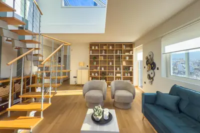 a living room with a blue couch and chairs at Acropolis Sky Retreat Jacuzzi & 3BR Maisonette in Athens