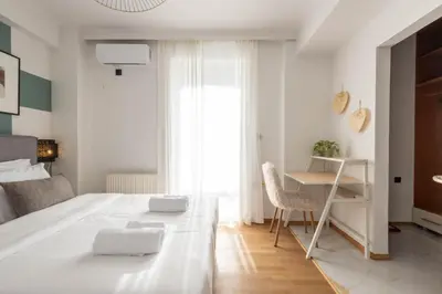 a white bedroom with a desk and a bed at Acropolis Sky Retreat Jacuzzi & 3BR Maisonette in Athens