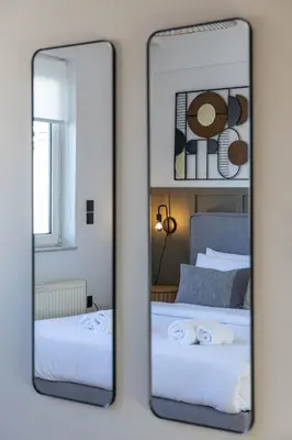 a mirror on a wall with two beds in a room at Acropolis Sky Retreat Jacuzzi & 3BR Maisonette in Athens