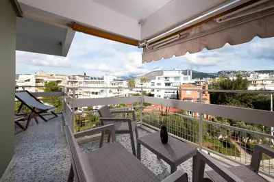 a balcony with chairs and a view of a city at Sea and City Voula Suite by First Class Properties in Athens