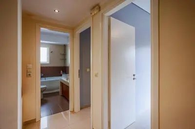 a bathroom with a toilet and a sink and a door at Athens Riviera Luxury Voula Residence in Athens