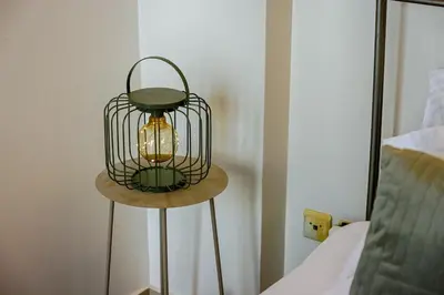 a lamp sitting on a table next to a bed at Athens Riviera Luxury Voula Residence in Athens