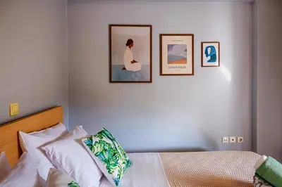 a bedroom with a bed with three pictures on the wall at Athens Riviera Luxury Voula Residence in Athens