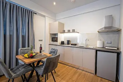 a kitchen and dining room with a table and chairs at Gina's Apartments in Spáta