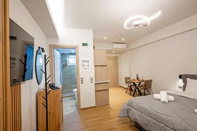 a bedroom with a bed and a dining room at Gina's Apartments in Spáta