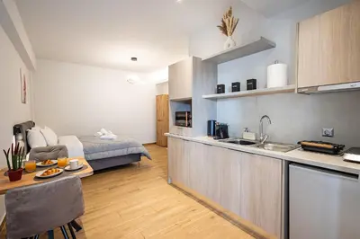 a kitchen and a living room with a bed at Gina's Apartments in Spáta