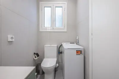 a white bathroom with a toilet and a window at Athens Lyrics in Athens