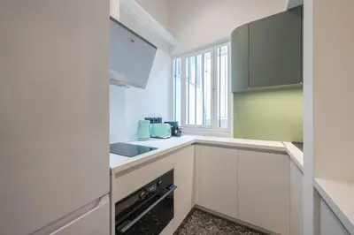 a kitchen with white cabinets and a sink at Athens Lyrics in Athens