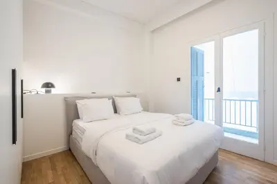 a white bedroom with a large bed with towels on it at Athens Lyrics in Athens
