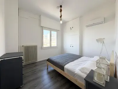 a bedroom with a bed and a desk and a window at Glyfada Center Apt 11 in Athens